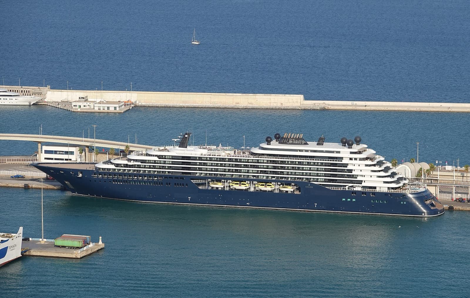 The Ritz-Carlton yacht Ilma berthed in the Port of Barcelona, her navy hull and tiered white decks in profile