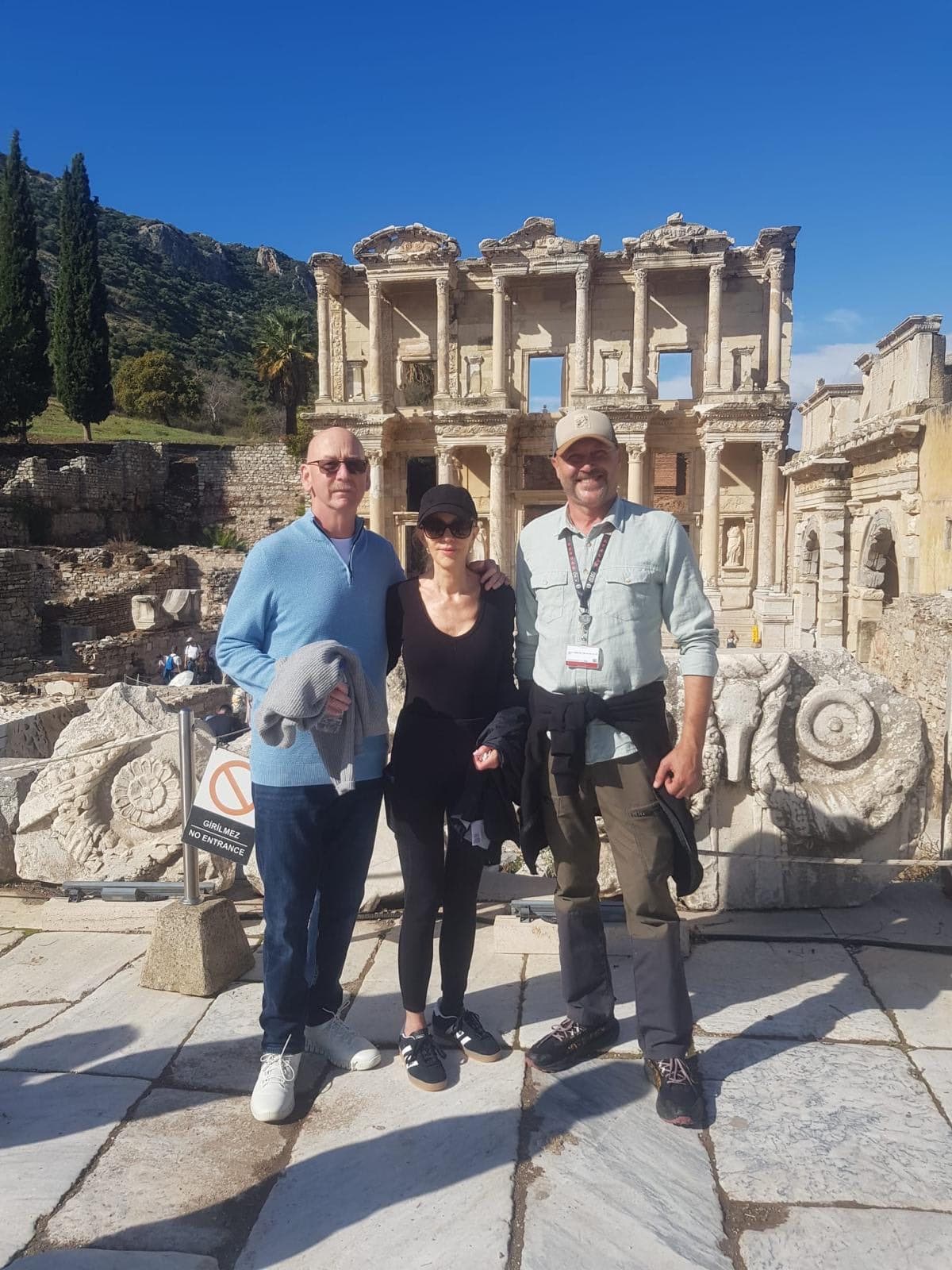 Two Azamara guests with their licensed guide Serdar Atalan, on the right, in front of the Library of Celsus at Ephesus on a private tour from Kuşadası cruise port, 29 October 2026