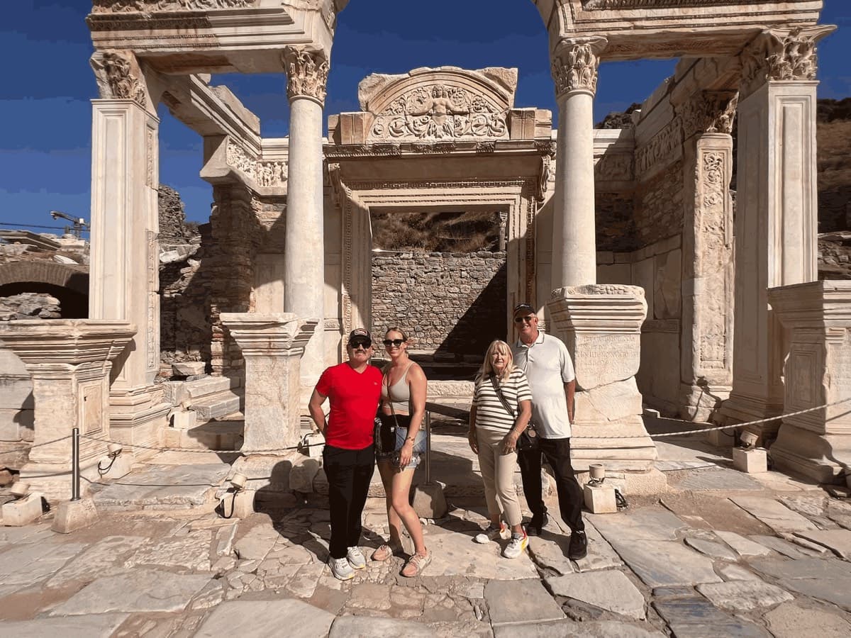 Four guests from the United States off Celebrity Ascent in front of the Temple of Hadrian on Curetes Street in Ephesus, the Medusa relief above its inner doorway, on a private Biblical Ephesus tour from Kuşadası cruise port, photographed by licensed English-speaking guide Hakan Cebeci, 22 October 2026
