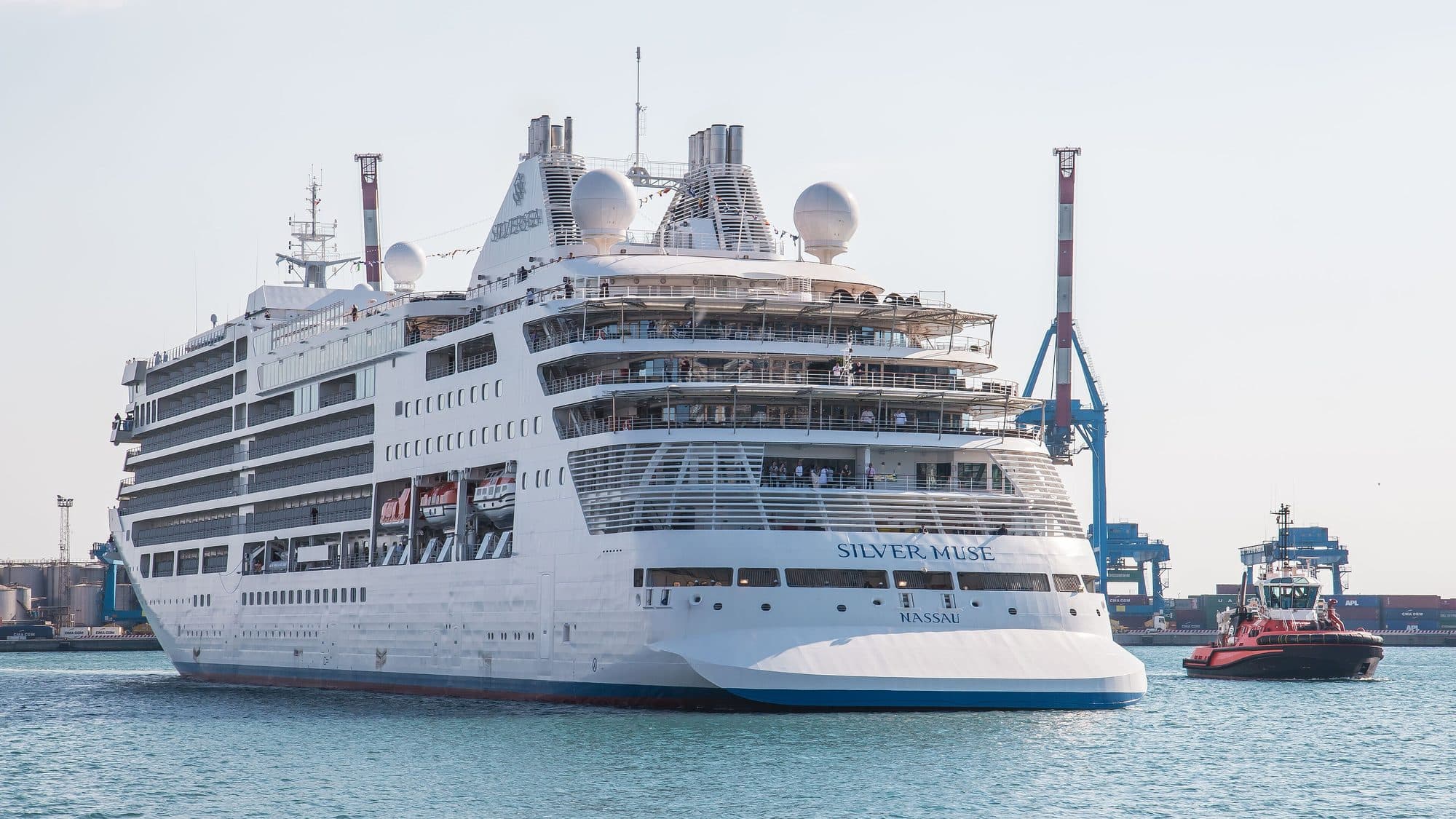 Silver Muse cruise ship leaving port with a tug alongside