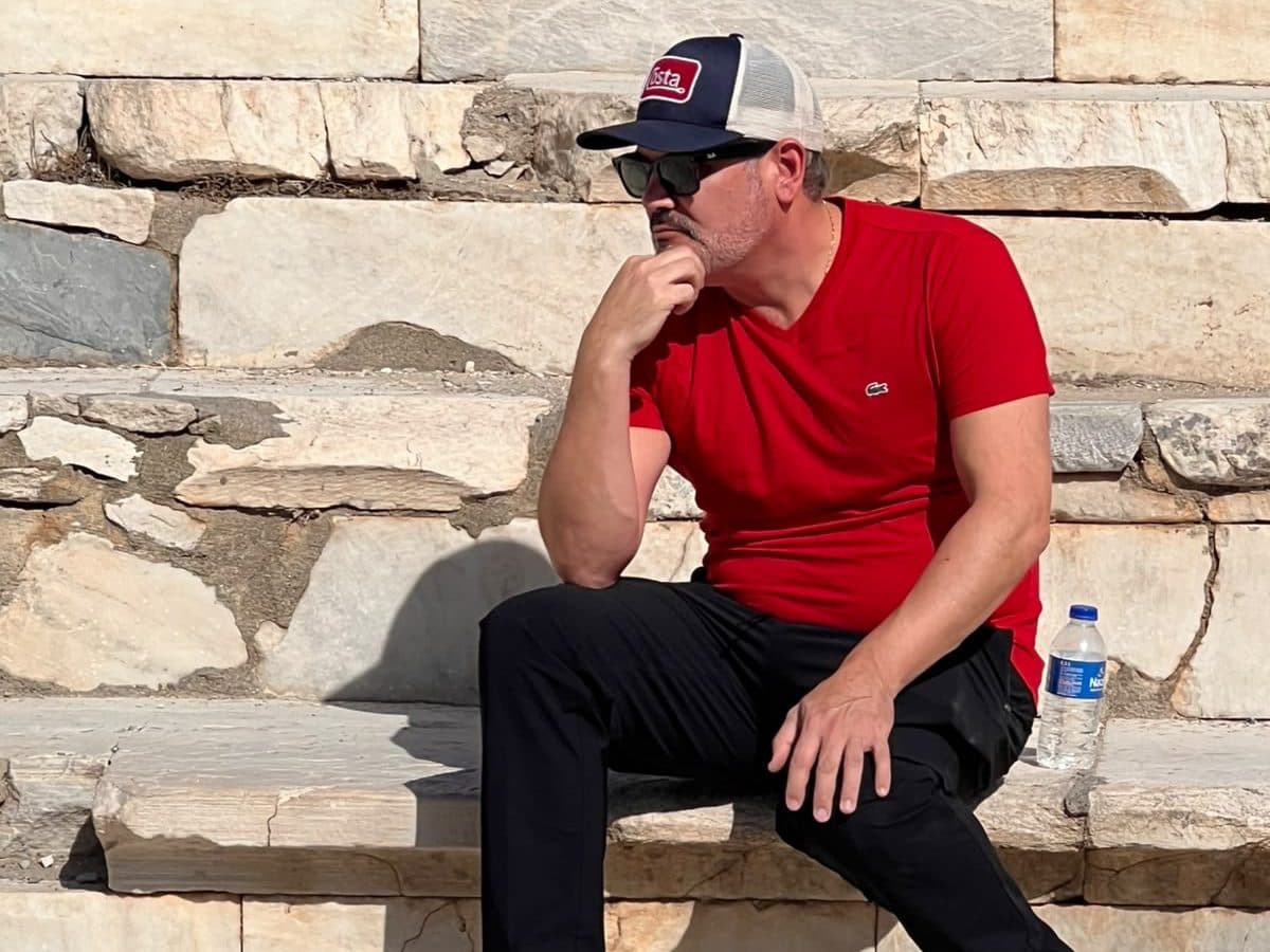 A guest from the United States off Celebrity Ascent seated in thought on the marble seats of the Great Theatre of Ephesus, the theatre of the riot in Acts 19, on a private Biblical Ephesus tour from Kuşadası cruise port, photographed by licensed English-speaking guide Hakan Cebeci, 22 October 2026