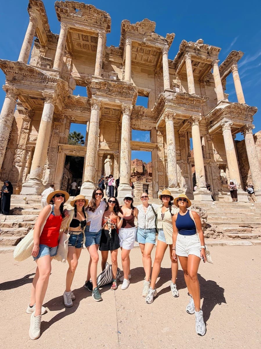 A birthday group of eight Celebrity Xcel guests in front of the Library of Celsus, Ephesus, on a private tour led by Tours of Ephesus guide Celal Ceylan, 9 September 2026
