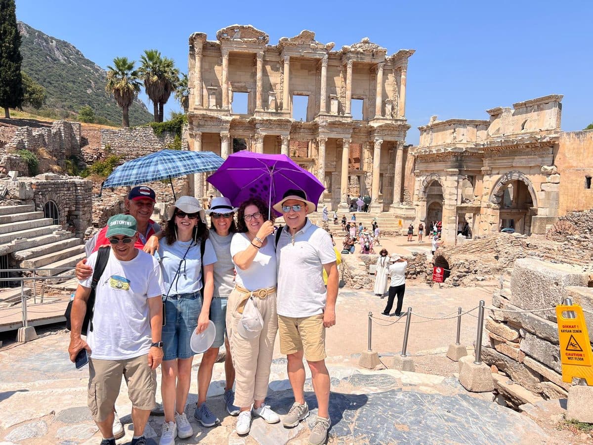 Six Celebrity Xcel guests under sun umbrellas in front of the Library of Celsus, Ephesus, on a private shore excursion from Kuşadası, 13 August 2026