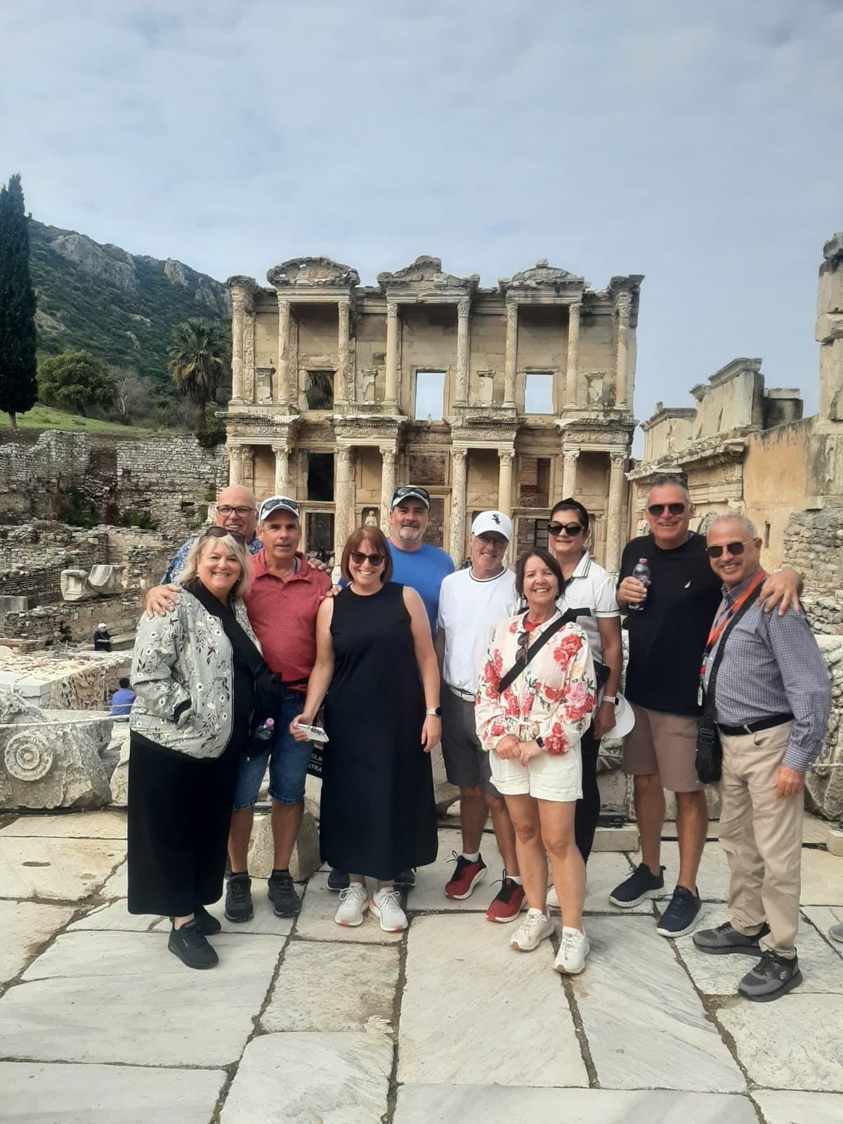 Licensed French- and English-speaking guide Eli Halegua, on the far right with his guide badge on a lanyard, with nine Canadian guests from Princess Cruises' Enchanted Princess in front of the Library of Celsus, on a private Ephesus and Temple of Artemis tour in French from Kuşadası cruise port, 30 October 2026