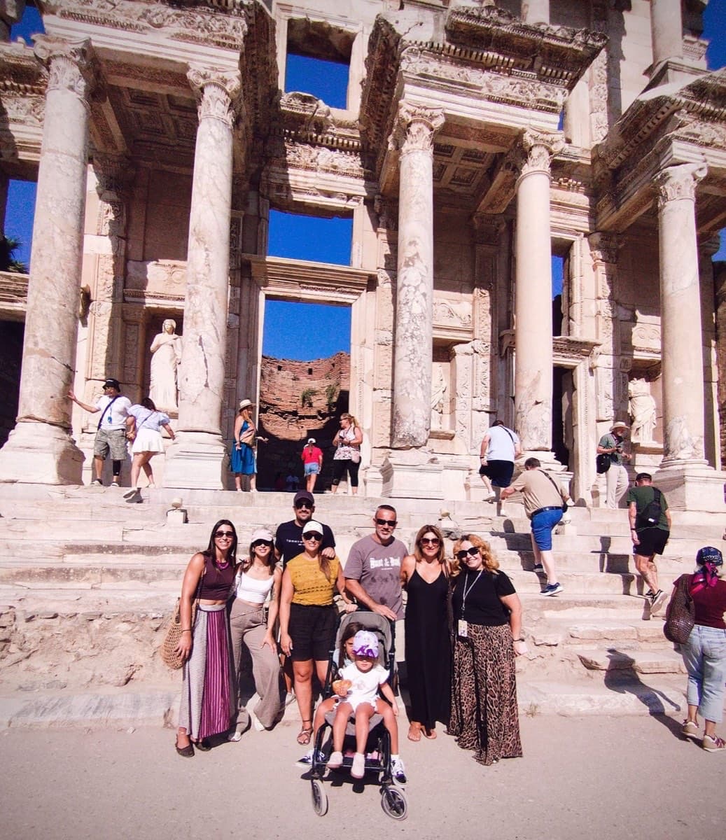 Tours of Ephesus guide Ferah Pekdemir with a family group of Enchanted Princess guests, the two youngest in a stroller, in front of the Library of Celsus, Ephesus, 5 September 2026