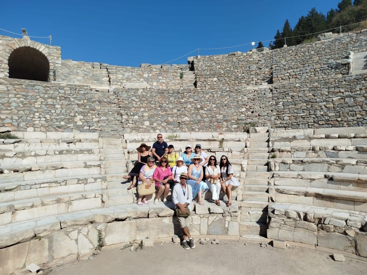 Russian-speaking licensed guide Cihan Yaşkaya with eleven MSC Divina guests on the marble seats of the Odeon at Ephesus, on a private Ephesus, House of the Virgin Mary and Temple of Artemis tour in Russian from Kuşadası cruise port, 21 September 2026