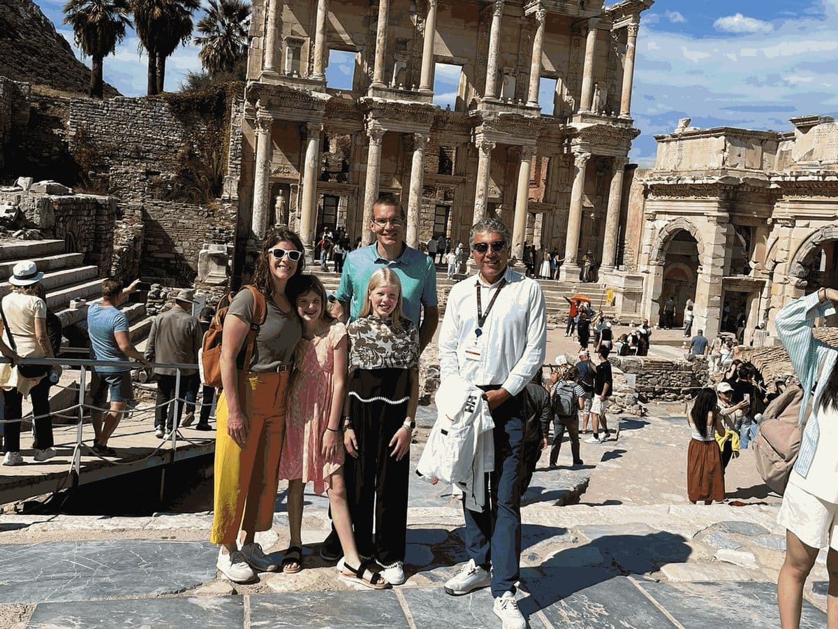 Licensed English-speaking guide İbrahim Pancar, on the right in a white shirt, with a family of four from Royal Caribbean Odyssey of the Seas at the foot of Curetes Street above the Library of Celsus and the Gate of Mazaeus and Mithridates, on a private Biblical Ephesus tour from Kuşadası cruise port, 3 October 2026