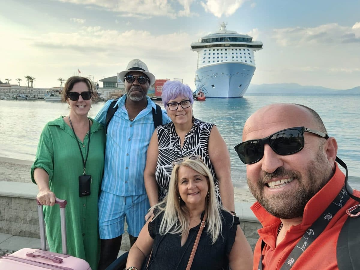 Licensed English-speaking guide Murat Fesli taking a selfie with four Odyssey of the Seas guests on the Kuşadası seafront, Royal Caribbean's ship at the cruise port behind them, as they head back to board after a private Ephesus, House of the Virgin Mary and Temple of Artemis tour, 30 September 2026