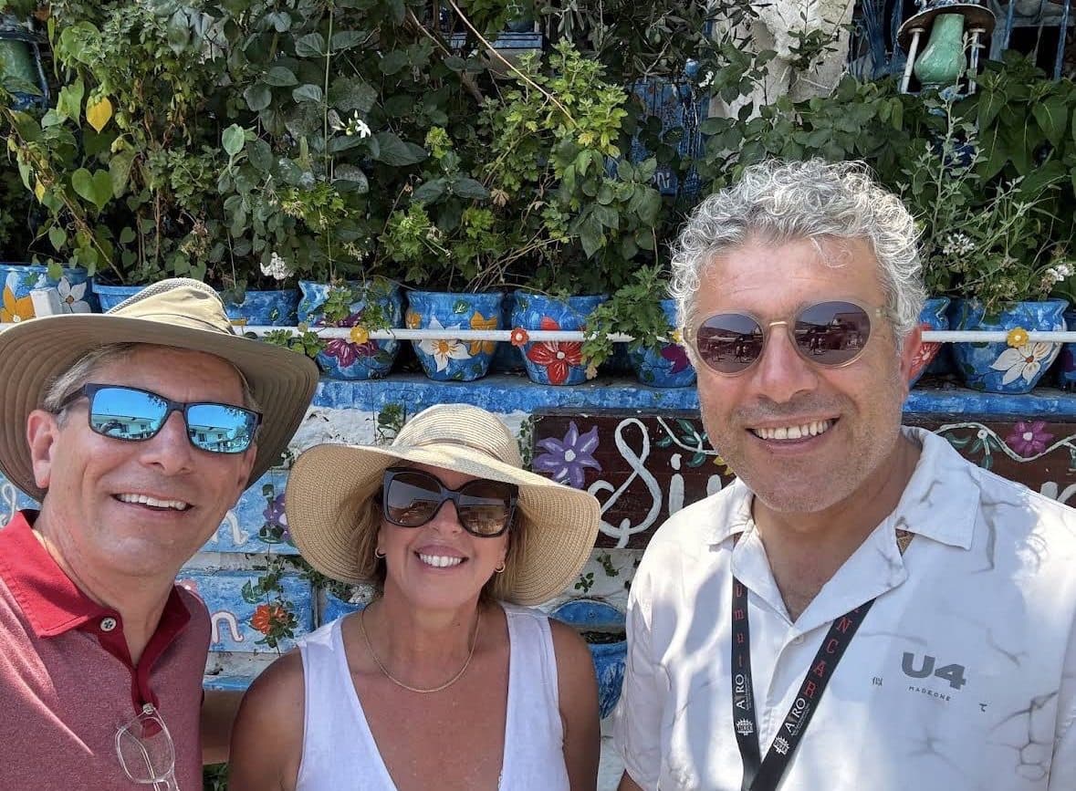 Tours of Ephesus guide İbrahim Pancar with two Silver Nova guests among the painted flowerpots of Şirince village, 14 August 2026