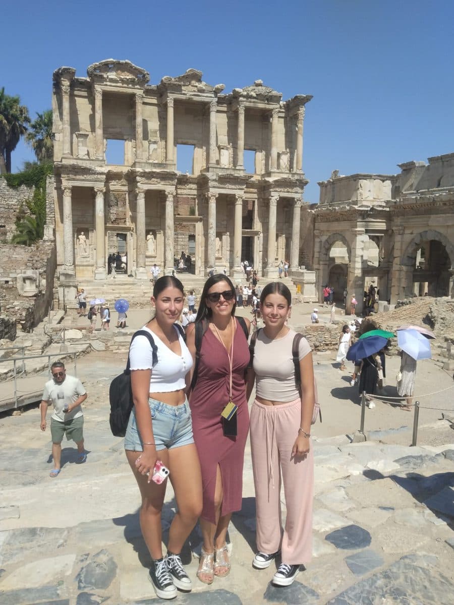Our licensed guide Ebru Ergün Tek with two MSC Divina guests in front of the Library of Celsus at the foot of Curetes Street, private Ephesus tour, 27 July 2026