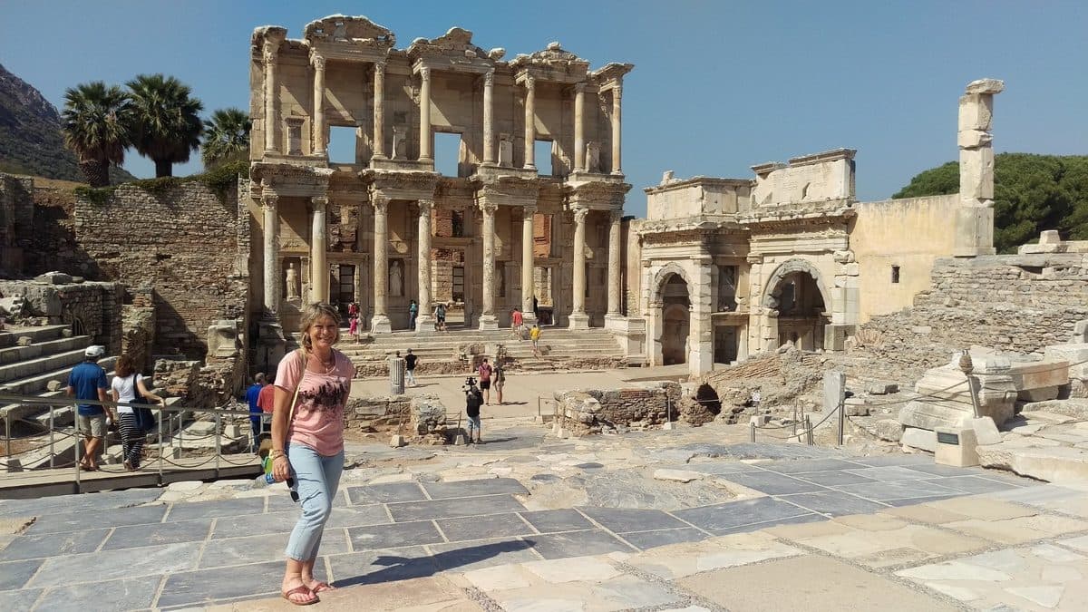 A guest on the marble plaza in front of the Library of Celsus, the centrepiece of a private Emerald Cruises shore day