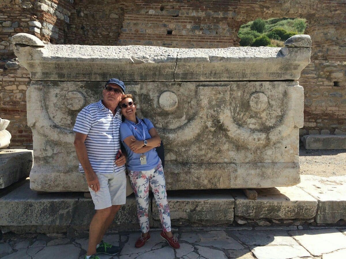 Guest with her Tours of Ephesus guide beside a carved sarcophagus in Ephesus