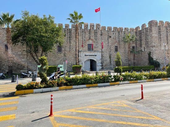 Stone gate and turreted walls of the 1618 Öküz Mehmed Paşa Caravanserai, the first stop on a walking loop from Kuşadası cruise port