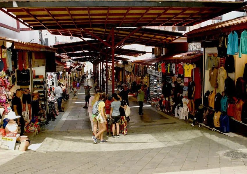 Narrow lane of the Kuşadası old town bazaar with shopfronts and awnings, minutes on foot from the cruise terminal
